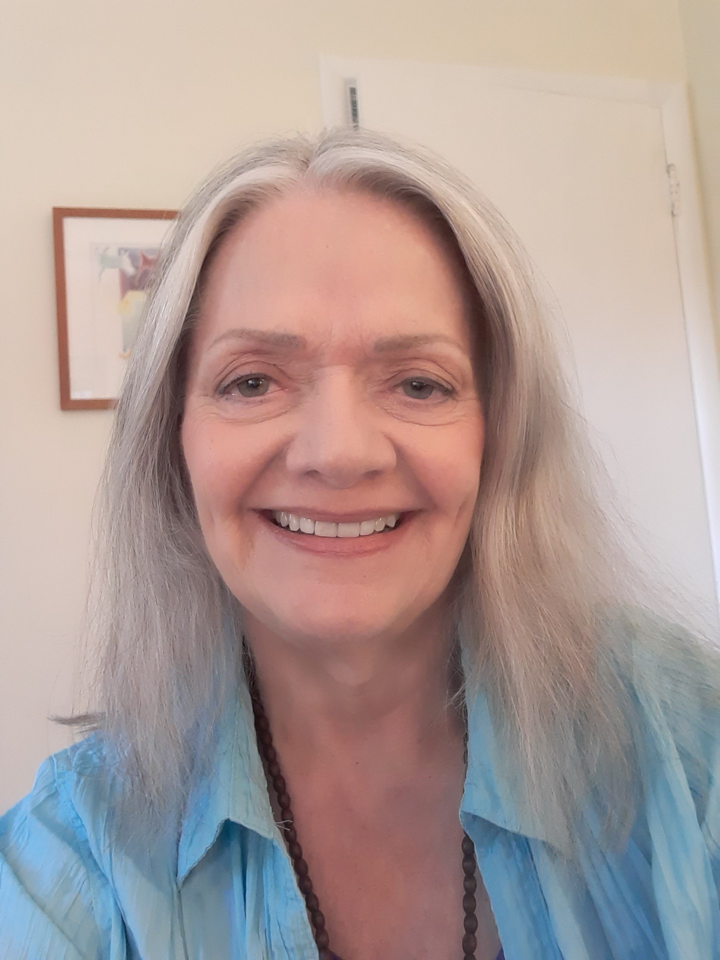 Smiling woman in blue shirt indoors.